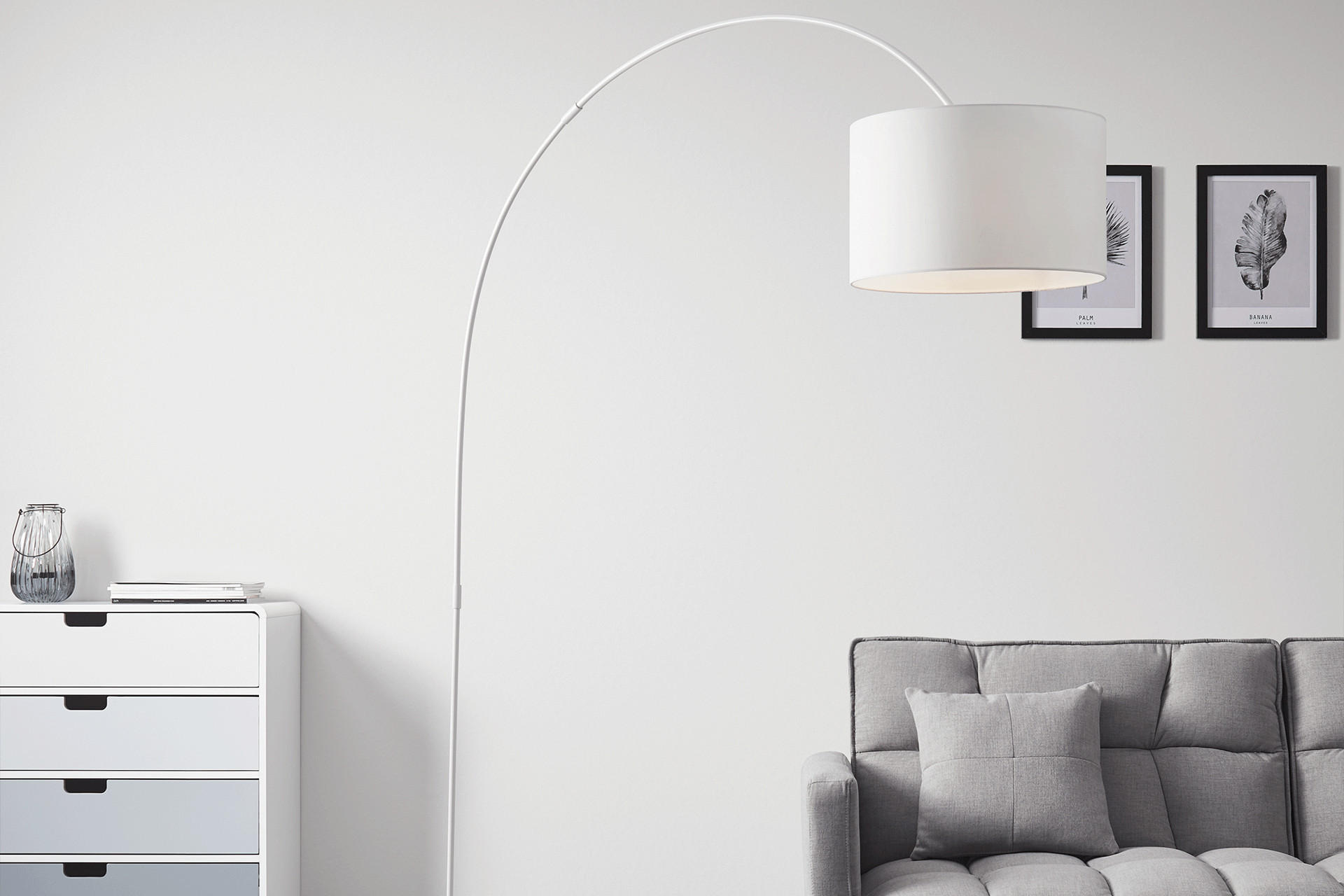 Stehlampe mit gebogenen Gestell und lackiert in weiß von mömax. 