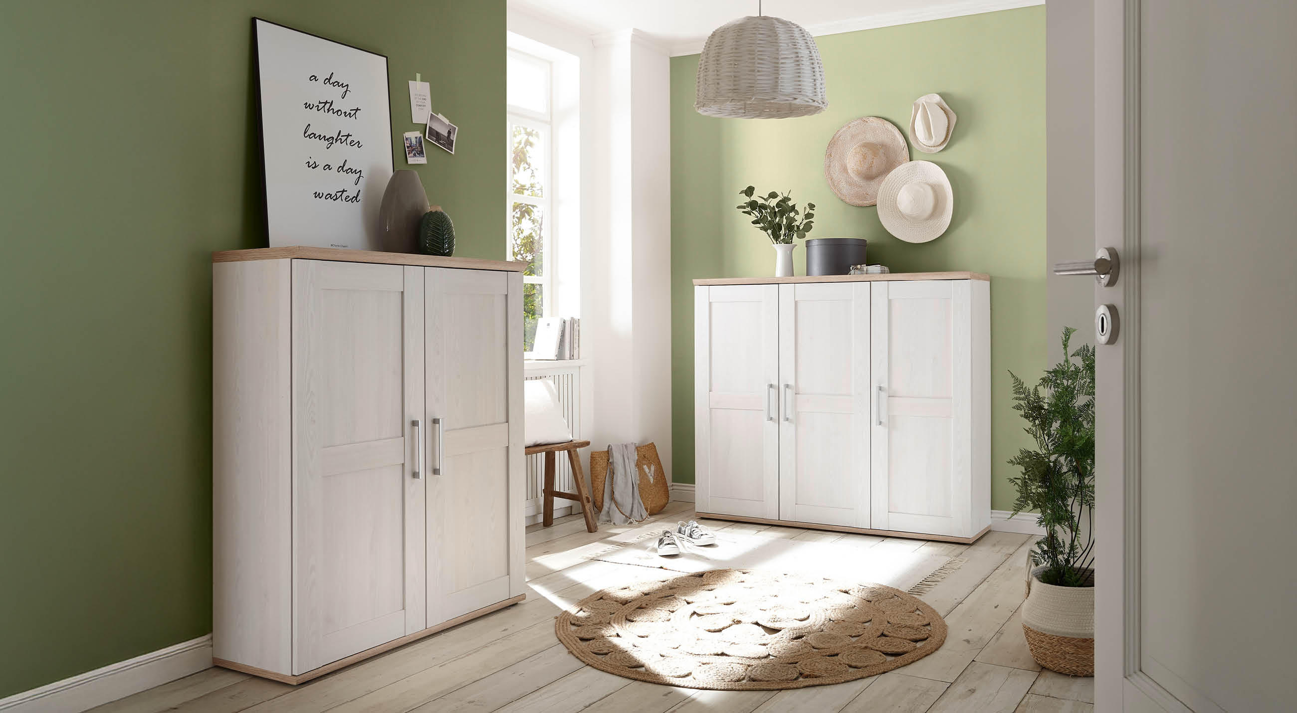 Eine weiße Garderobenserie aus Holz platziert an einer grünen Wand und einem Teppich in der Mitte.