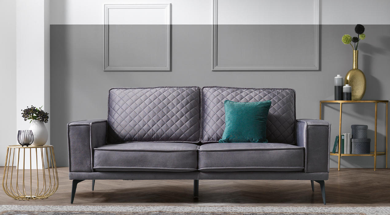 Graues Big Sofa mit Steppung und grünem Kissen