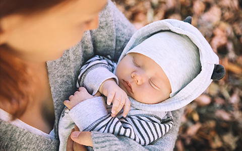 Baby schläft in Armen von Mutter