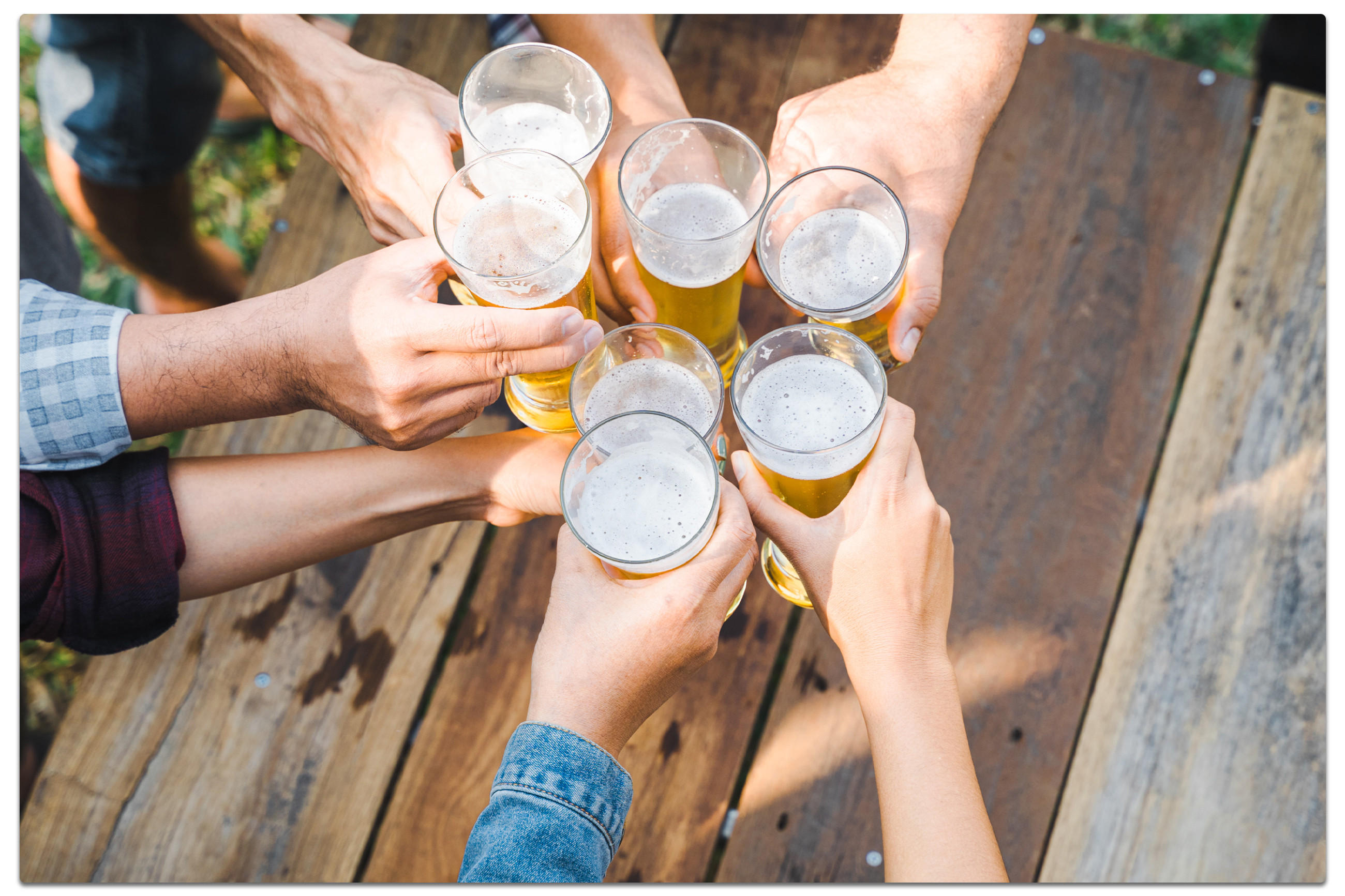 Eine Gruppe von Menschen stößt mit Biergläsern an, um das Oktoberfest zu Hause zu feiern.
