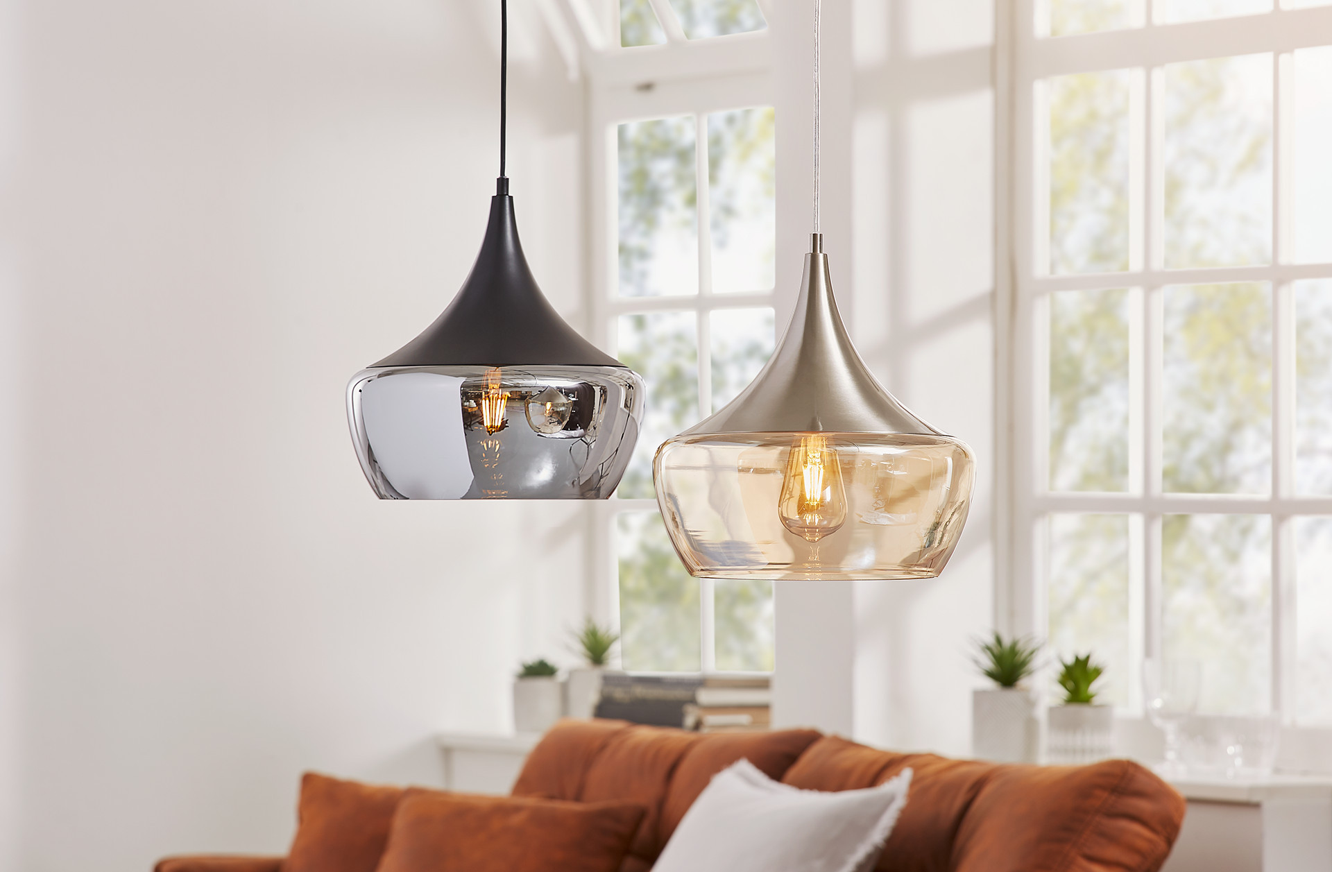 Dve moderné závesné svietidlá s kovovými tienidlami a skleneným dnom
