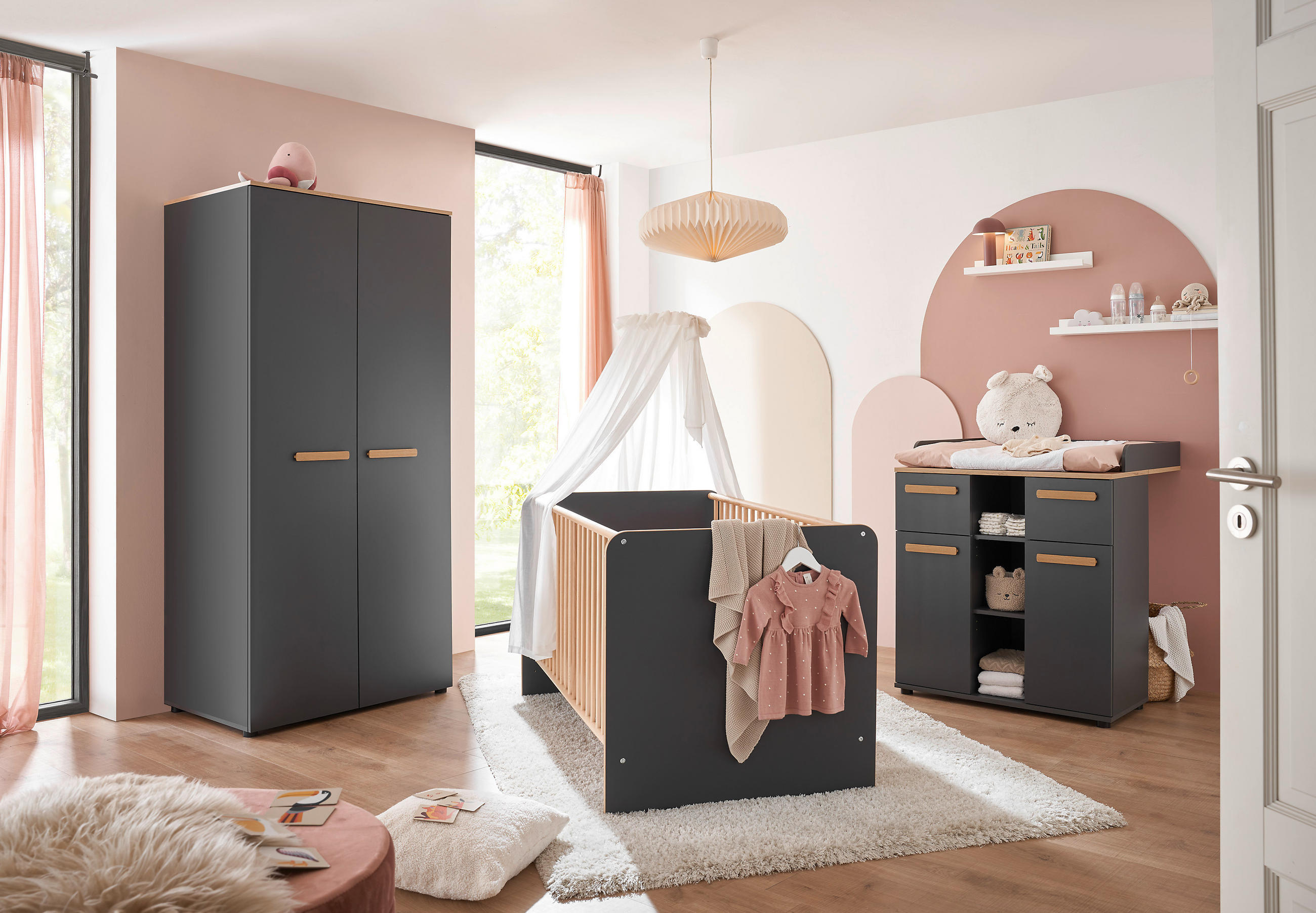 Soba za dojenčke z roza zidovi in pohištvom, prijetna in topla atmosfera.