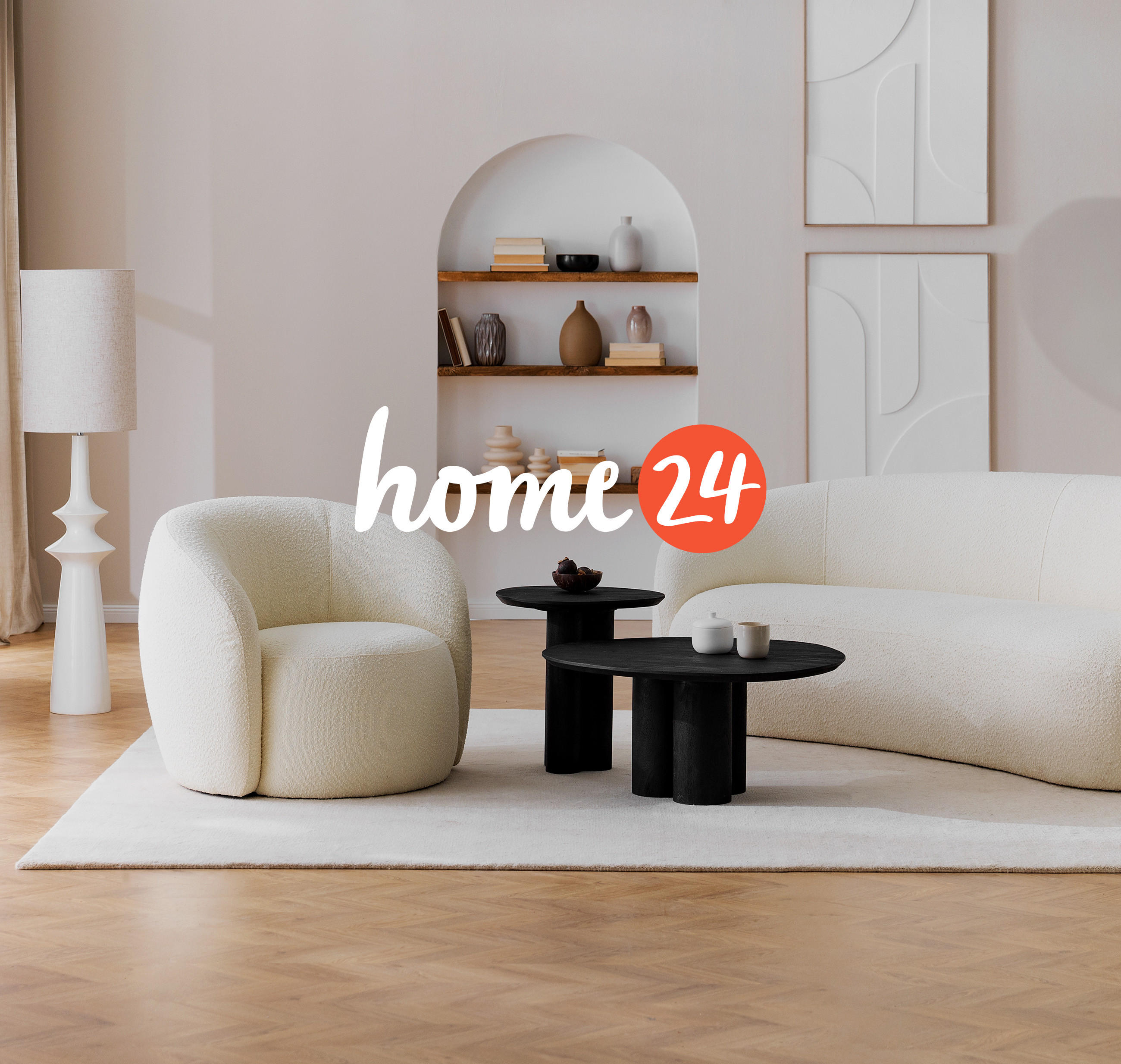 Modernes Wohnzimmer mit cremefarbenem Sessel und Sofa, schwarzen Couchtischen und minimalistischer Deko – Home24 Logo im Vordergrund.