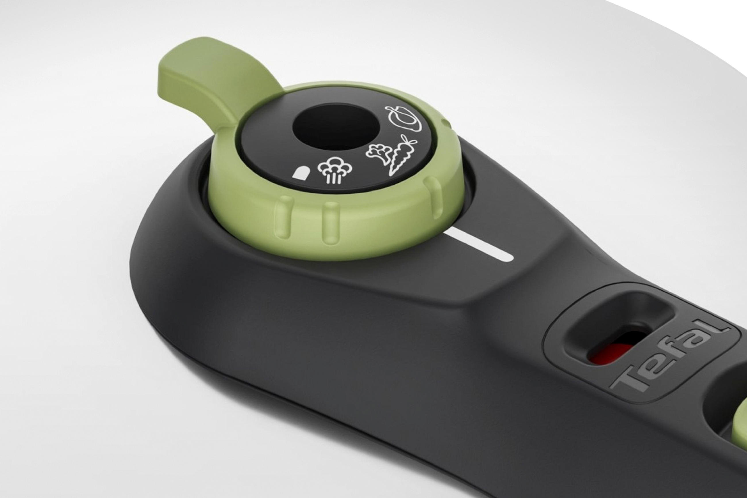 Närbild av ett Tefal-tryckkokarlock med en grön ventilvred. Vredet har symboler för olika tillagningslägen, inklusive grönsaker och ånga.