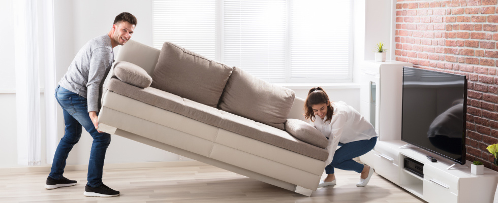 Frau und Mann heben Sofa