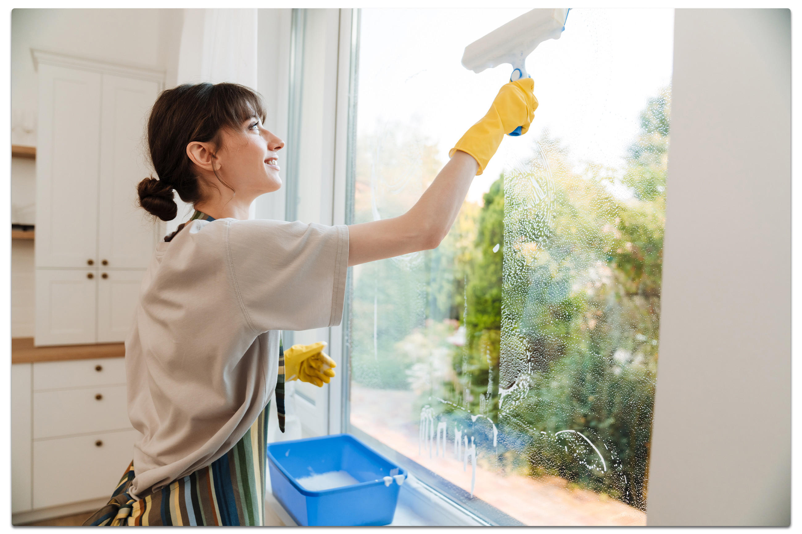 Frühjahrsputz: Eine Frau putzt ein Fenster mit einem Squeegee.