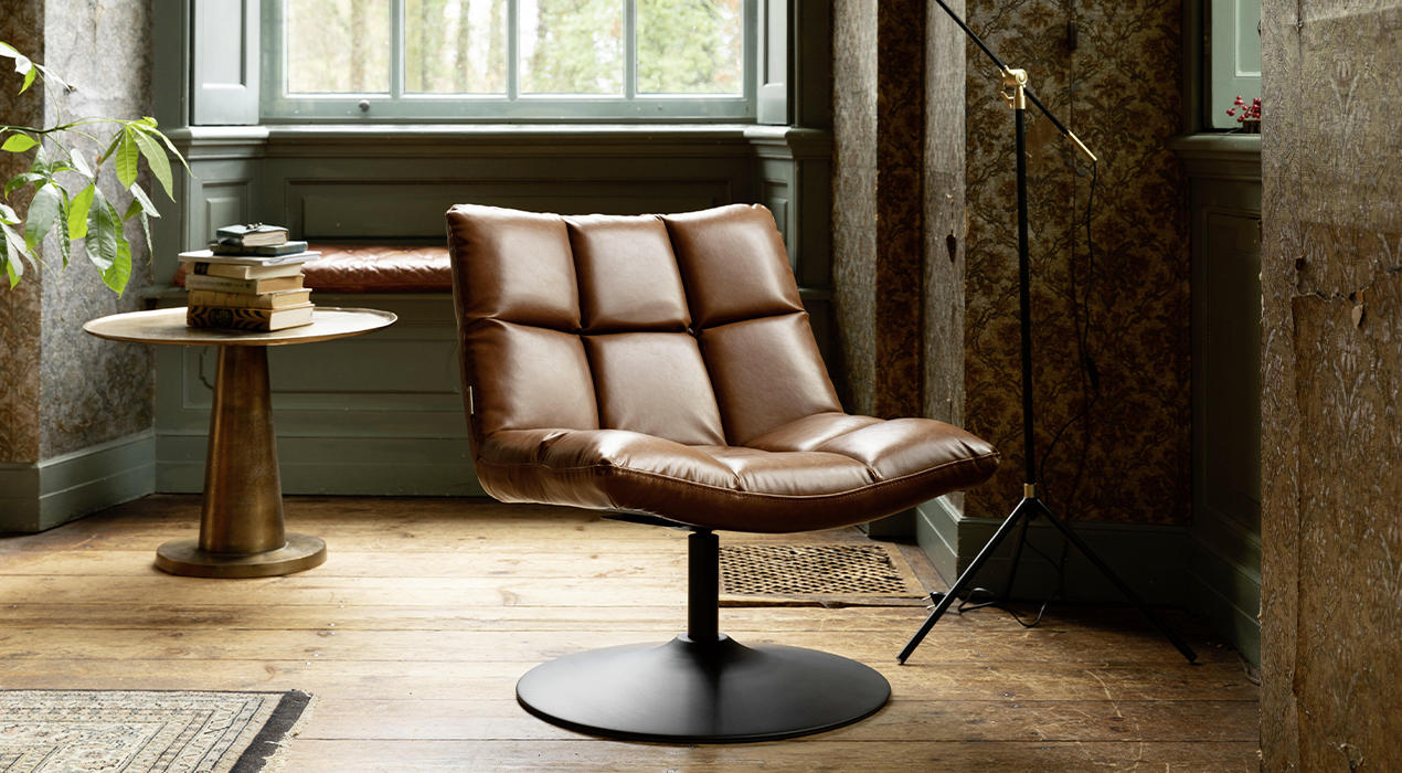 Hellbrauner Lederlook-Polstersessel mit Steppung und Bodenplatte.