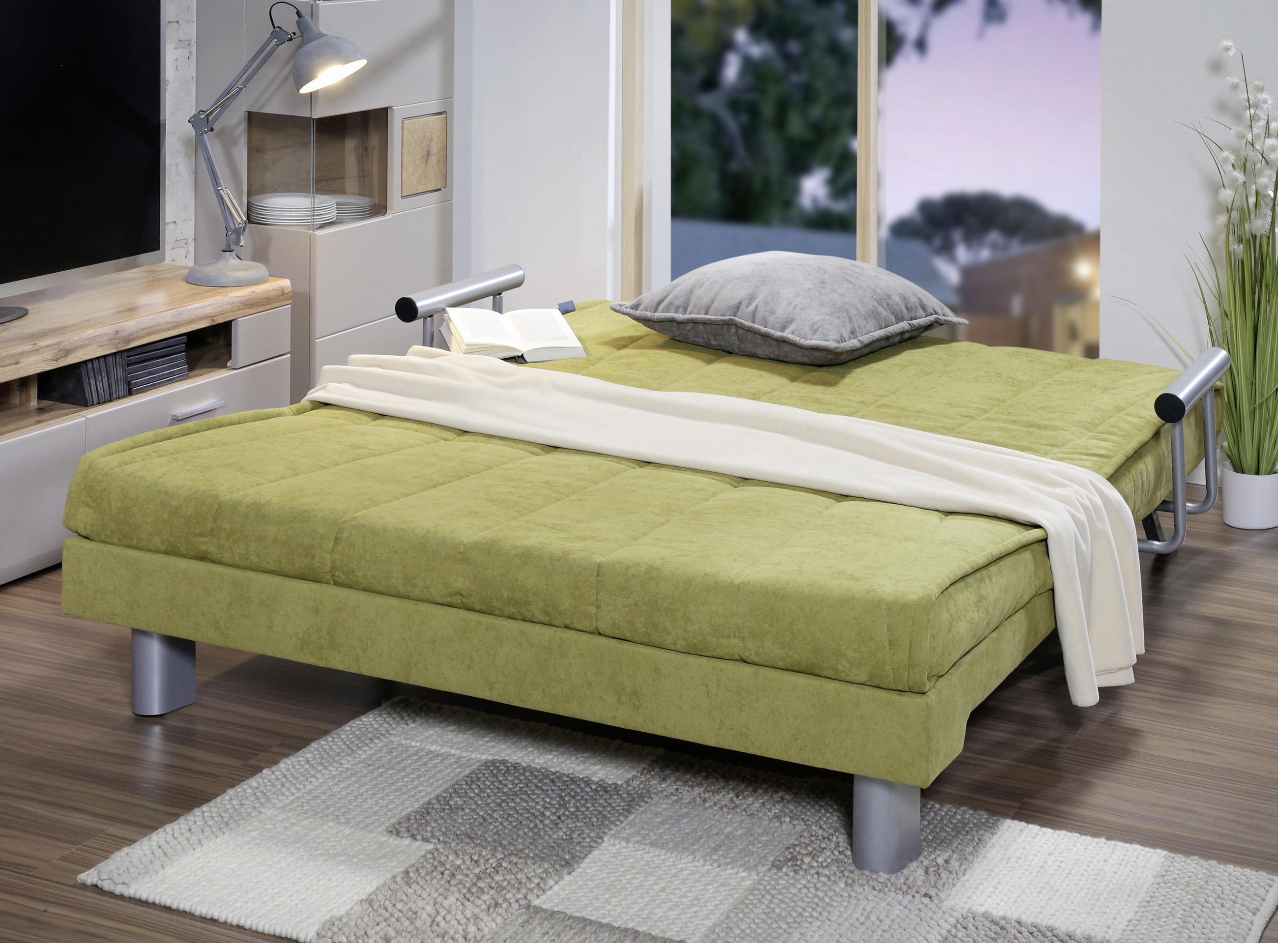 Udoben trosed s funkcijo ležišča v barvi pistacije.