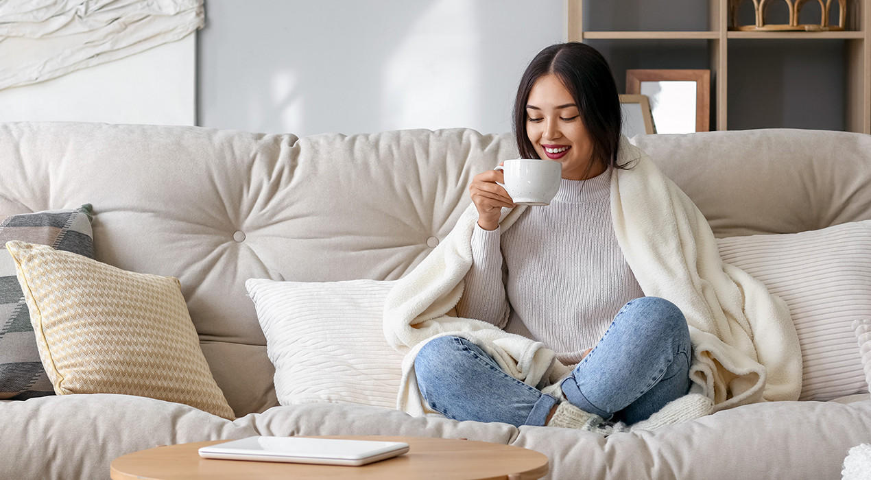 Frau trink Kaffee auf Sofa