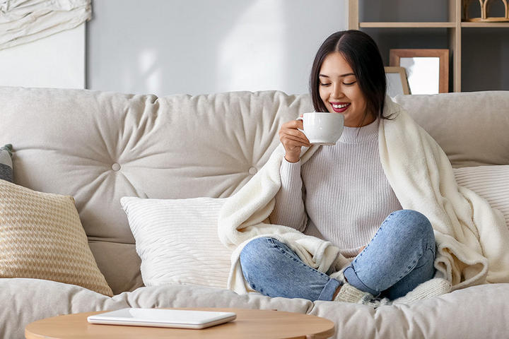 Frau trink Kaffee auf Sofa