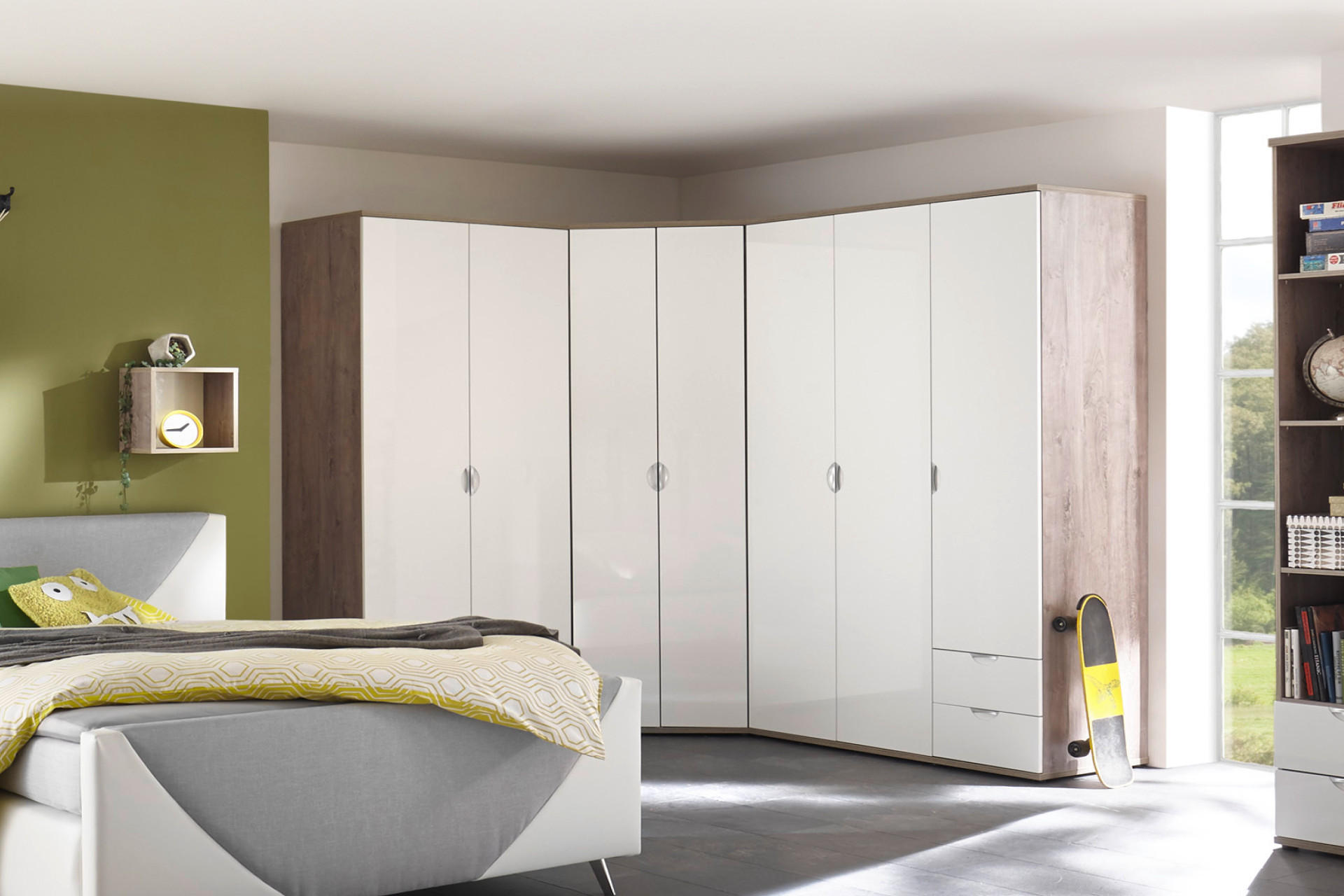 moderna spalna: biela rohova skrina so zelenou stenou, skateboard opretý o skriňu
