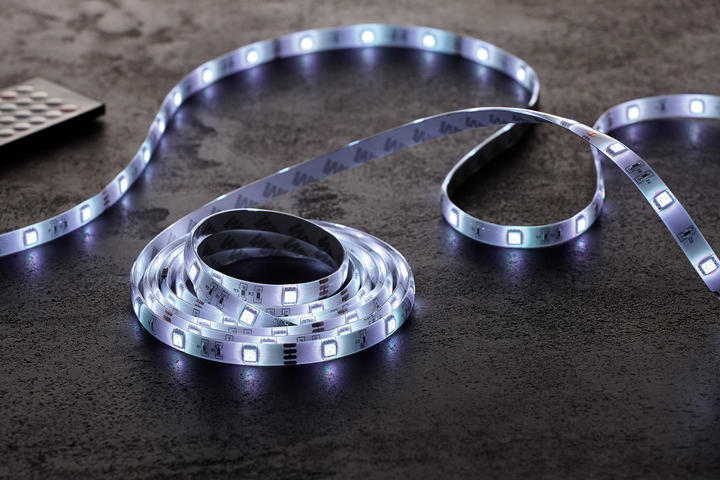 LED svetelný pásik s diaľkovým ovládačom, položený na tmavom povrchu, biele osvetlenie