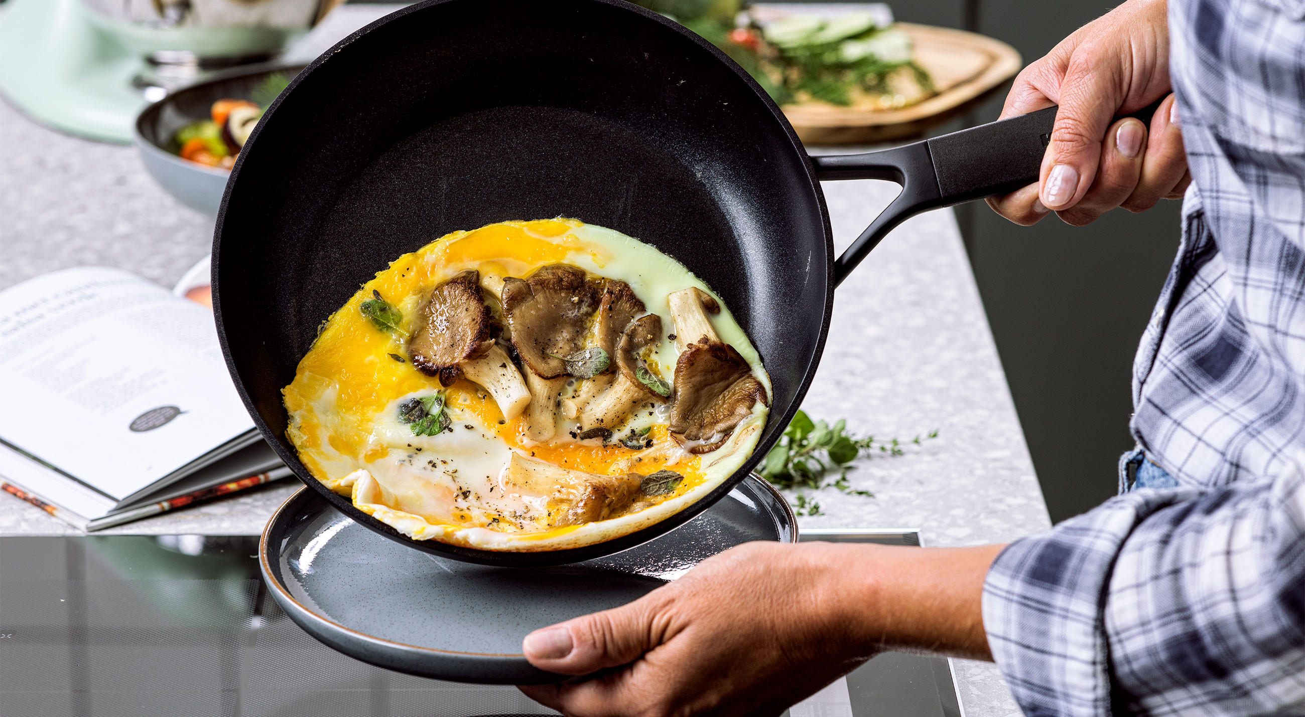 Mann serviert ein Eiergericht, aus der Classic Forged Aluminium Pfanne von KitchenAid.