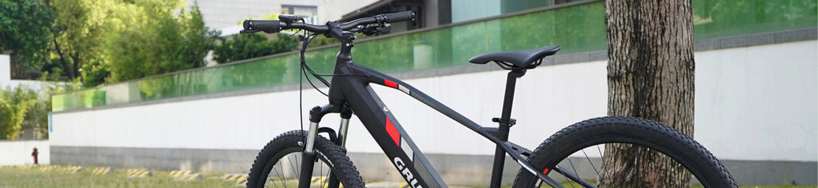 Ein schwarzes E-Bike mit einem Fahrradsattel, geparkt an der Seite eines Gebäudes.