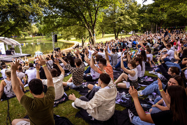 XXXLutz Azubis sitzen auf dem Gras und genießt die Natur beim Rookie Festival 2024