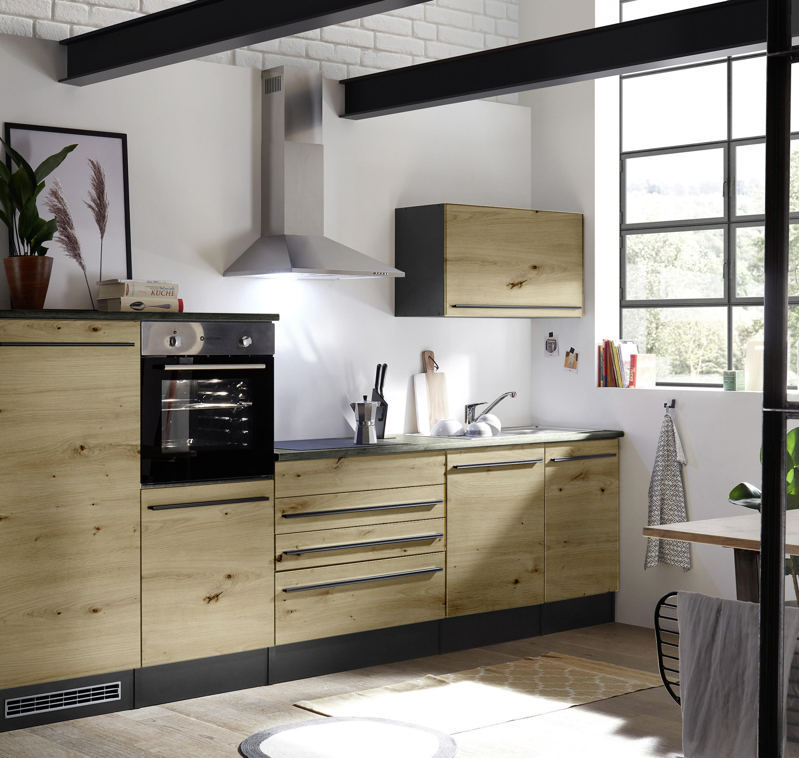 Helle Single-Küche in Holzoptik mit dunkler Arbeitsplatte, integriertem Backofen und Dunstabzugshaube; daneben Spüle, Hängeschrank und großes Sprossenfenster, das den kompakten Kochbereich lichtdurchflutet.