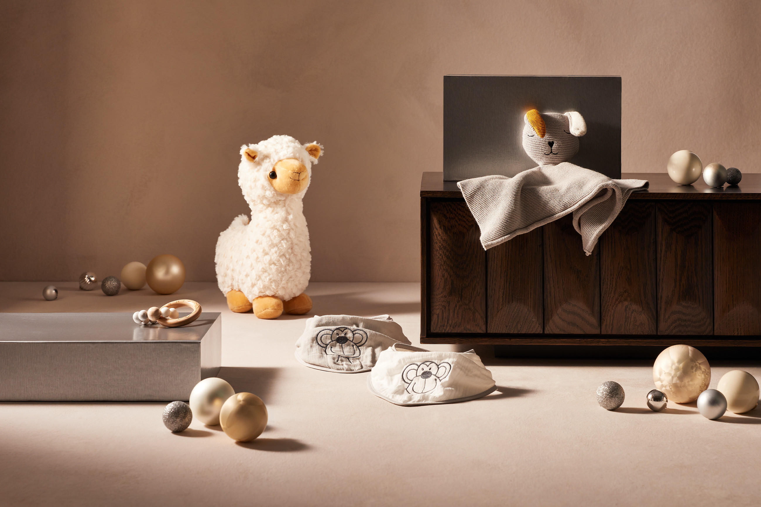 Kuscheltiere für Babys in weihnachtlicher Atmosphäre mit Christbaumkugeln