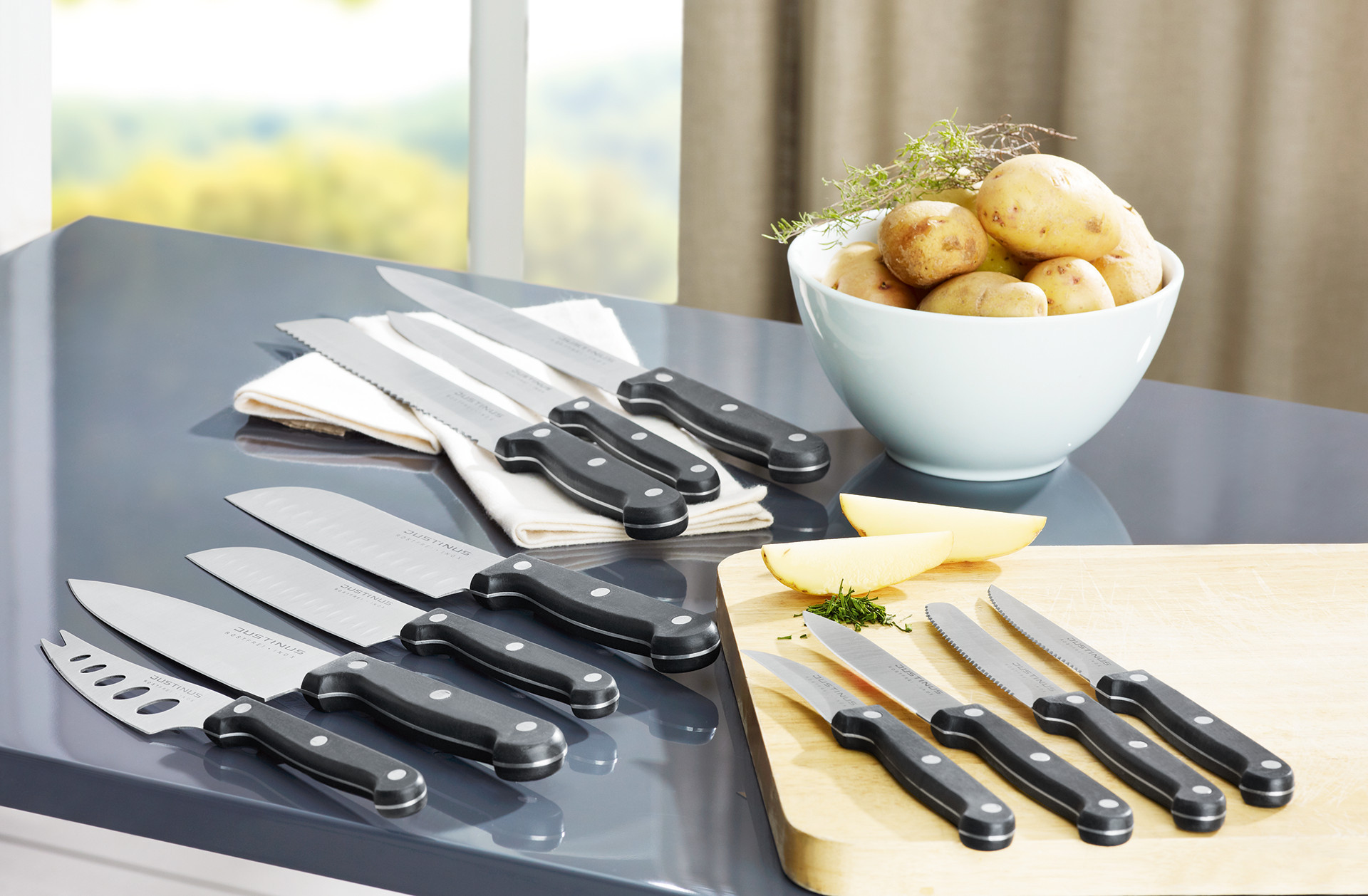 Sada kuchynských nožov, kuchynské nože, kuchárske nože, zemiaky v bielej miske, biela miska, drevená doska na krájanie