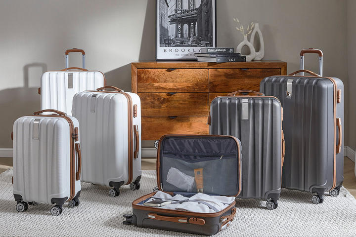 Koffer mit Rollen und Griffen in verschiedenen Größen stehen bereit für die Reise.