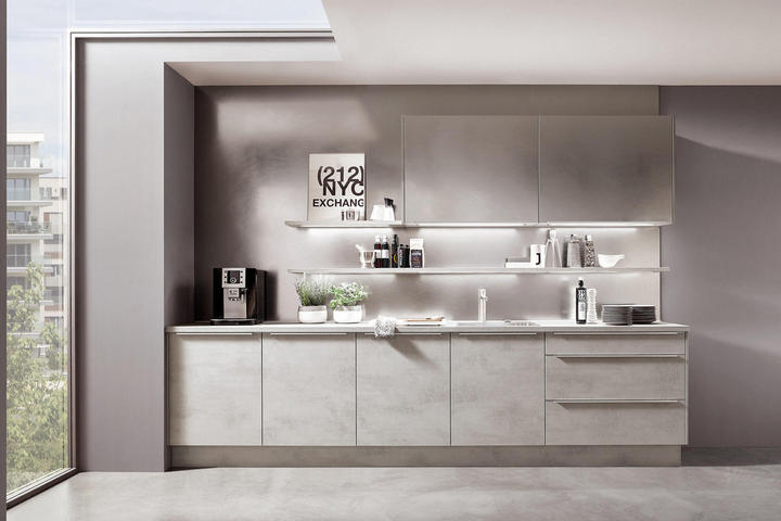 Moderne Küche mit hellgrauen Schränken, offenen Regalen, Kaffeemaschine und Deko, darunter ein Wandbild mit „212 NYC EXCHANGE“