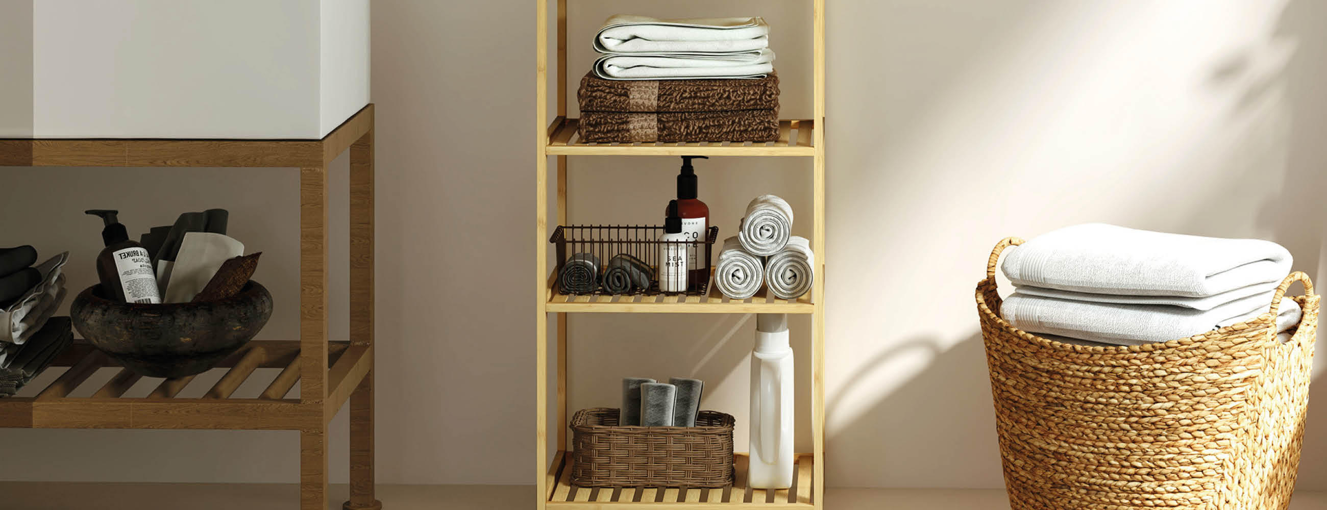 Offenes Holzregal mit gefalteten Handtüchern, Kosmetikflaschen und Körben neben einem geflochtenen Wäschekorb mit weißen Handtüchern in einem hellen Badezimmer