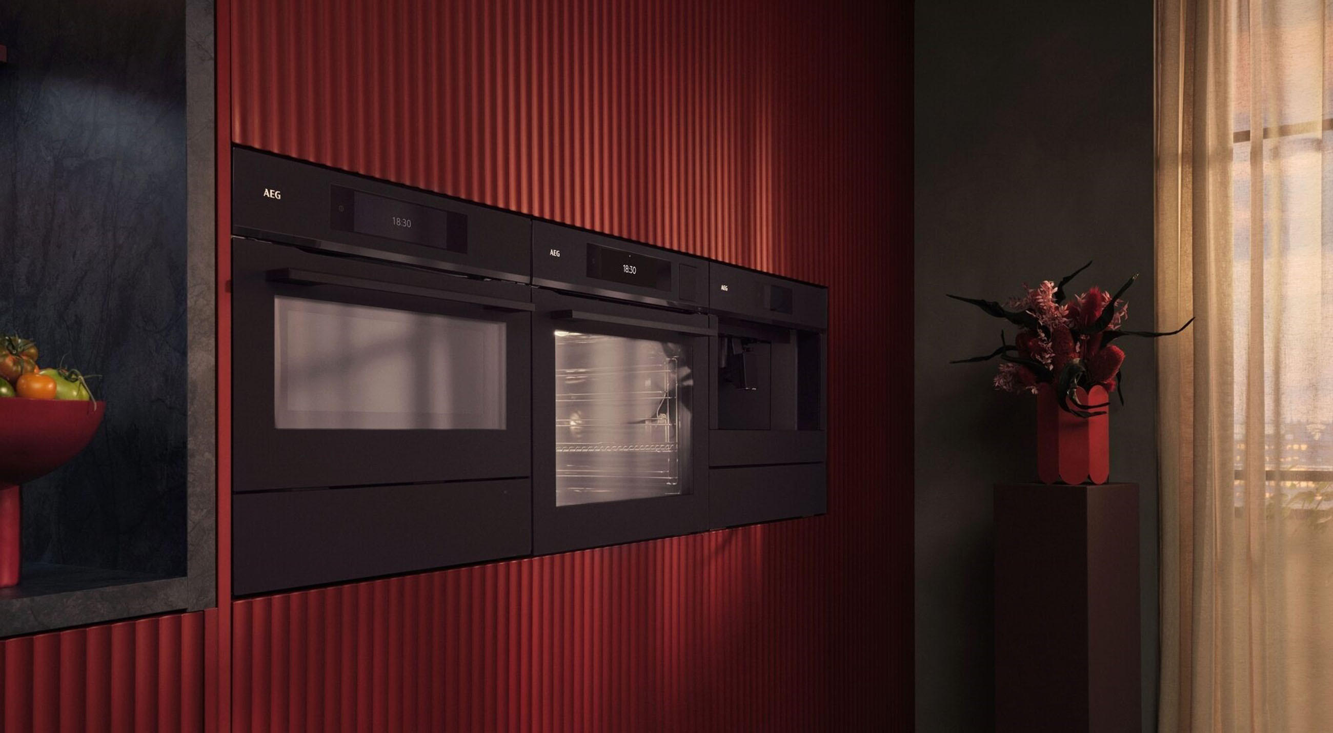 Stilvolle Küche mit roten Wänden, schwarzen Geräten und einem AEG-Backofen im Mittelpunkt.