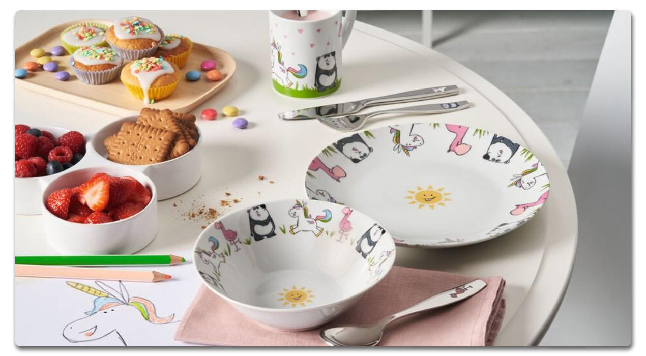Kindergeschirr in weiß, mit Verzierungen und essen auf dem Tisch