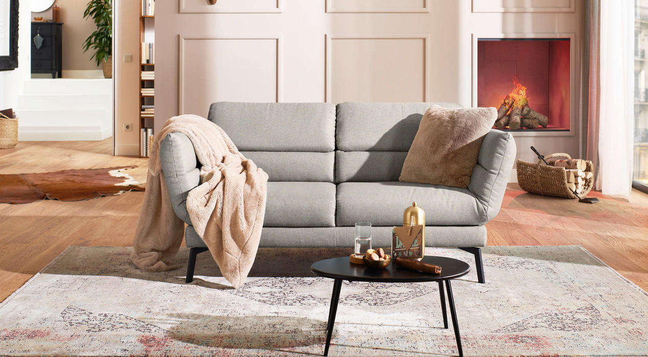 hellgraue 2sitzer couch mit beiger decke