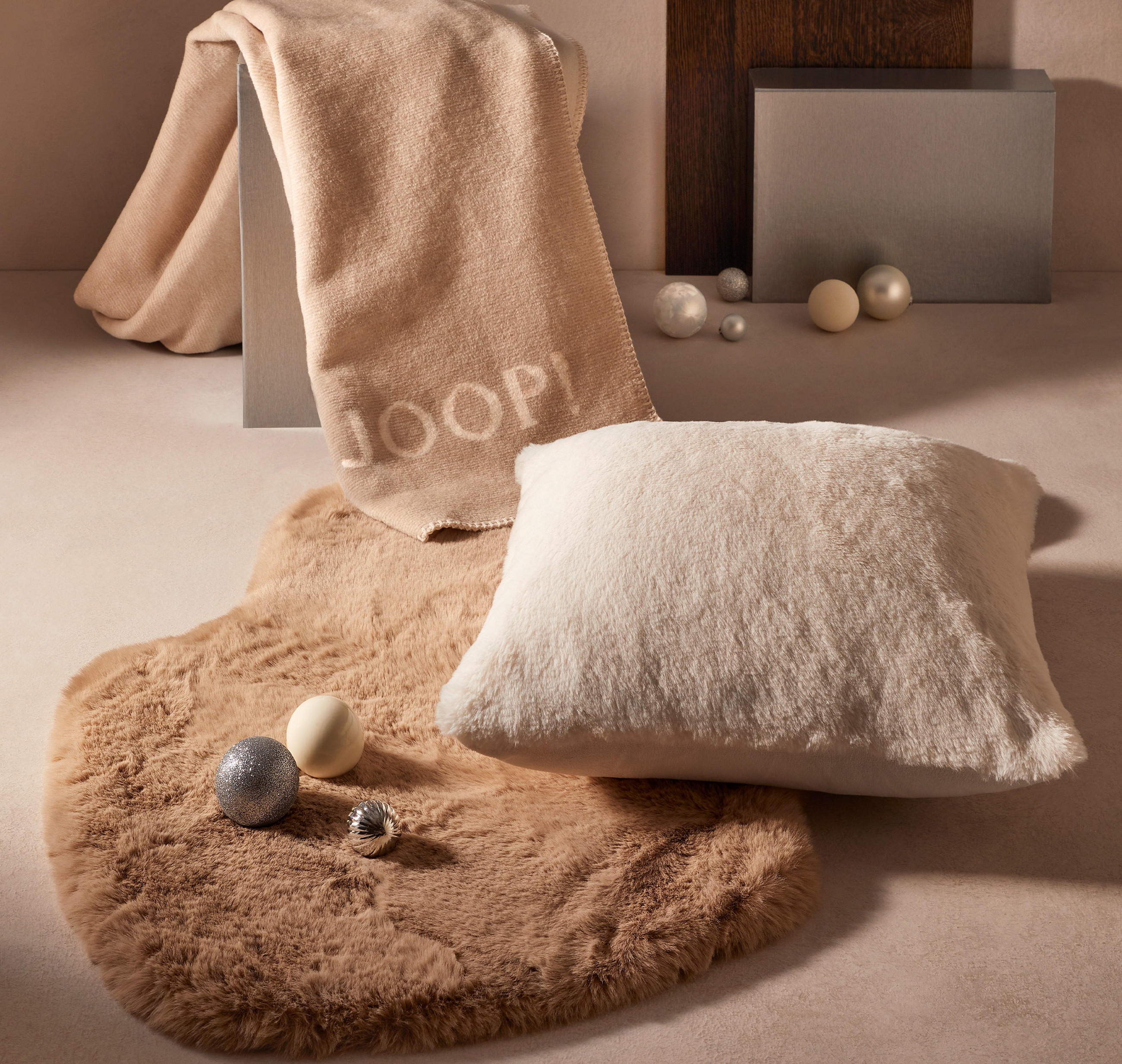 Kuscheldecken und Kissen in weihnachtlicher Atmosphäre mit Christbaumkugeln