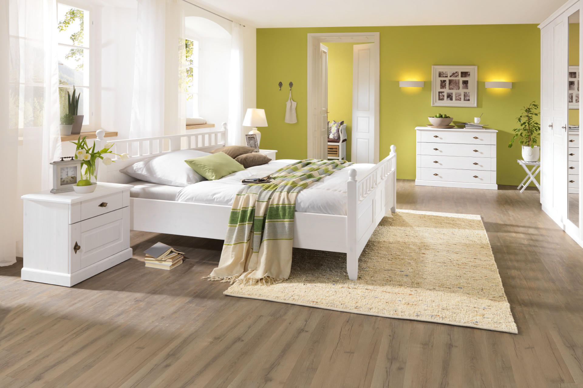 WeiÃes Bett mit grÃ¼nen Dekoelementen