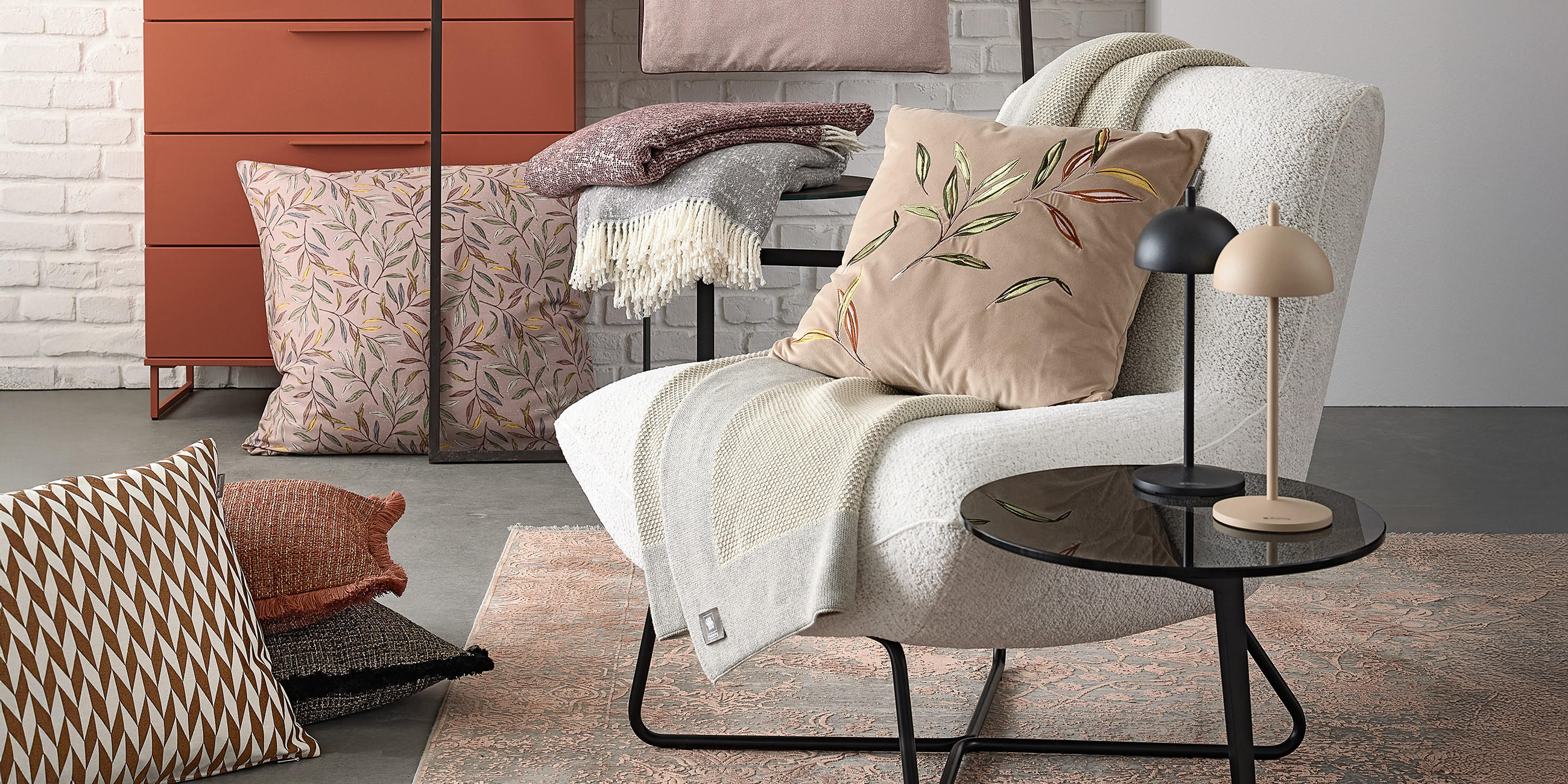 Wohnaccessoires von MUSTERRING, Grauer Sessel mit unterschiedlichen Textilien