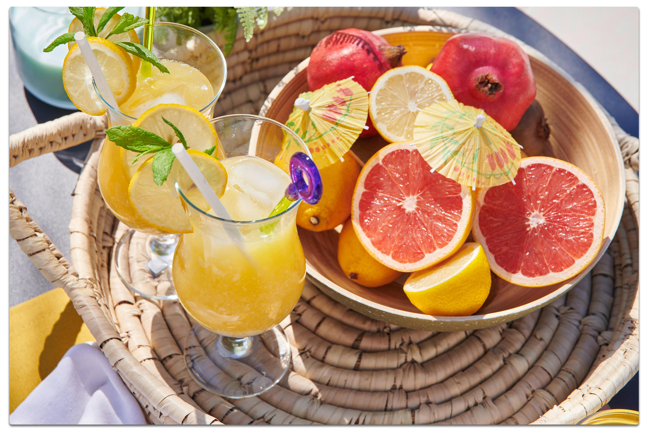 Ein Korb mit zwei Gläsern Limonade und einer Schale Obst