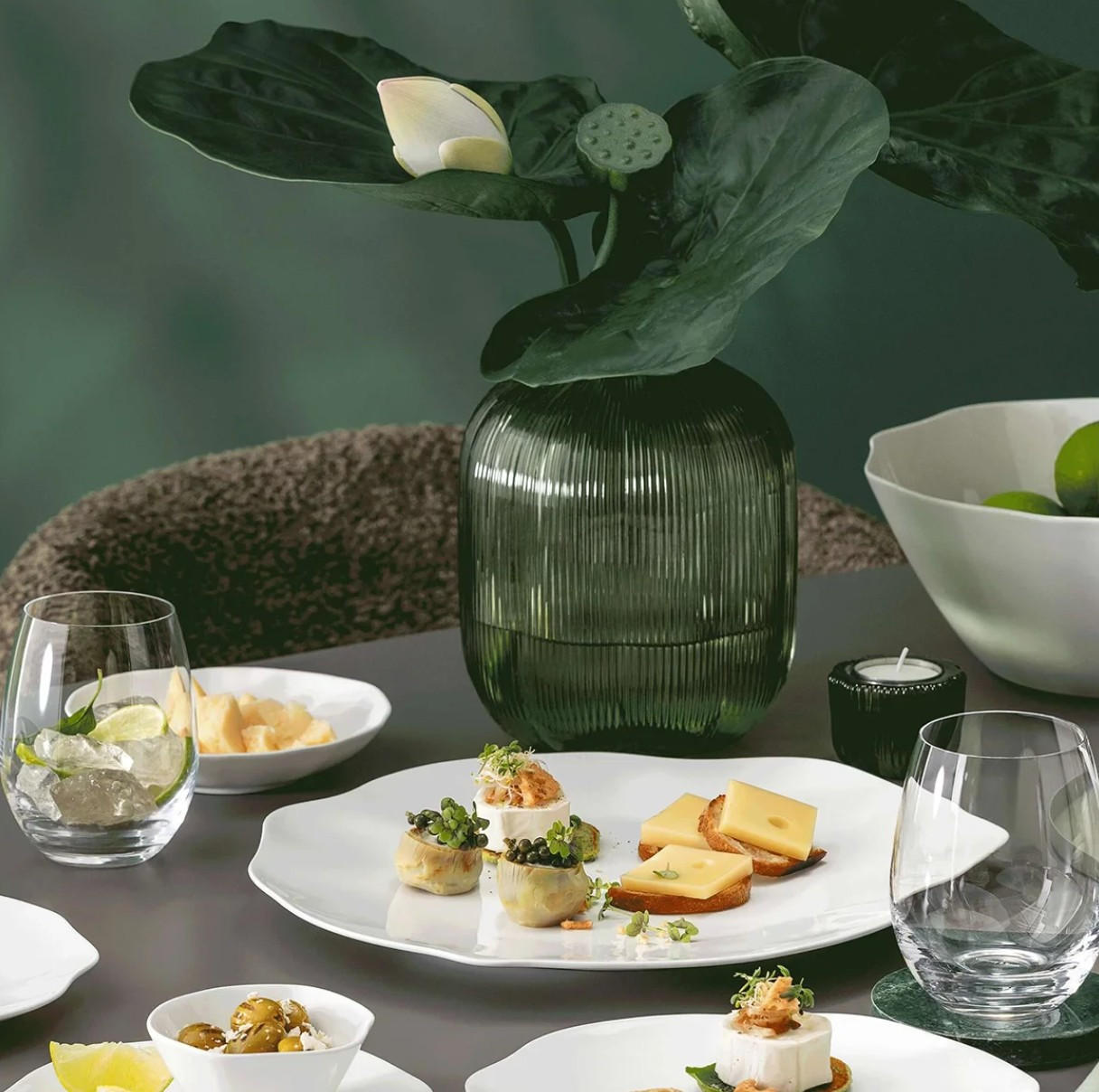Villeroy&Boch fehér porcelán étkészlet terített asztalon, üveg vizespohár, zöld üveg vázában zöld virág