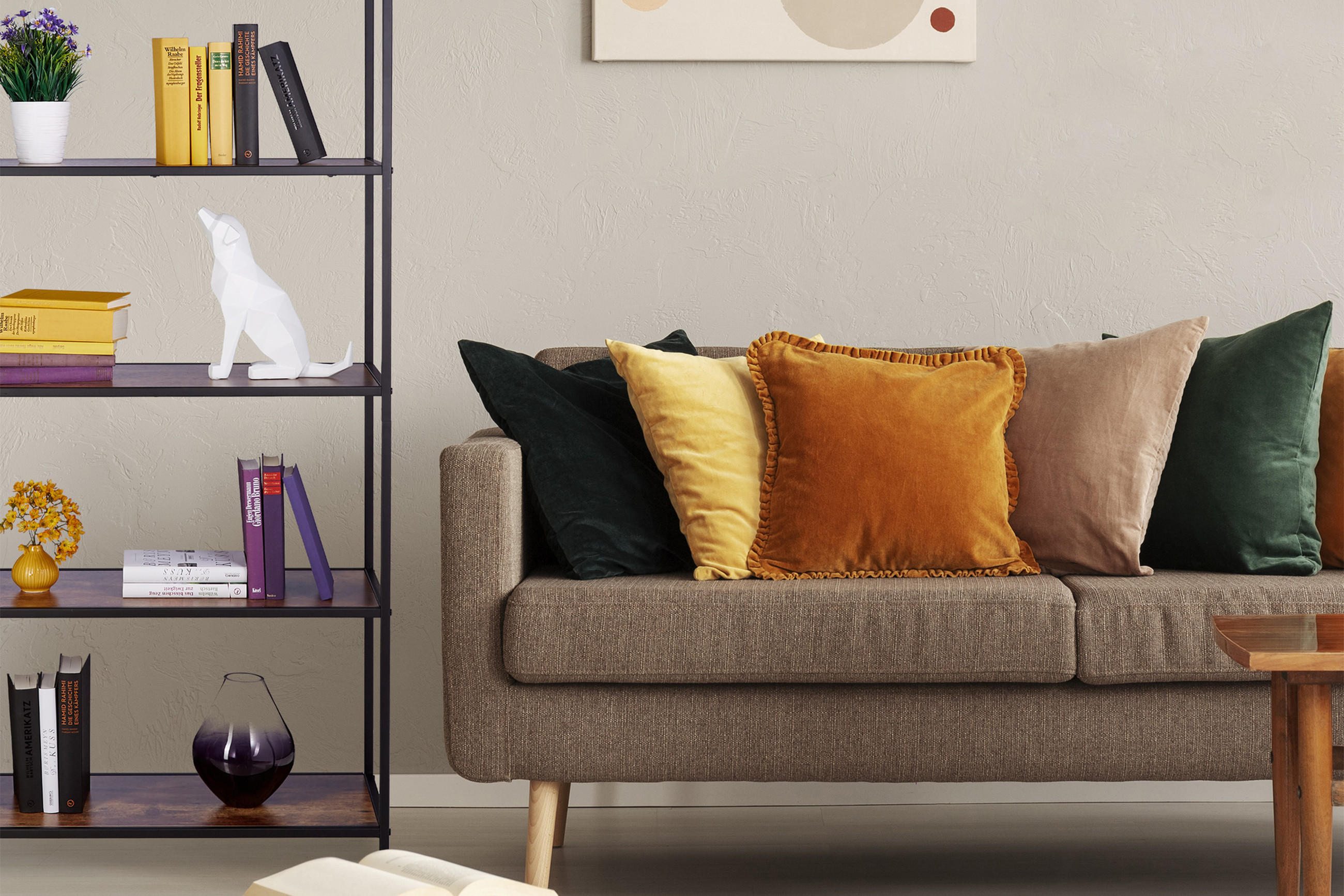 Couch mit bunten Kissen und Bücherregal