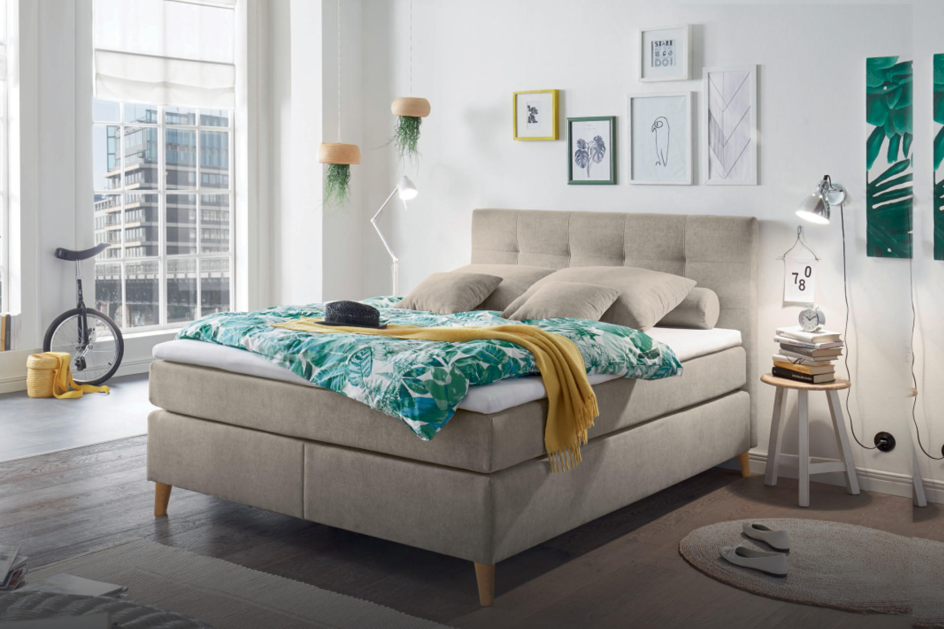 Béžová postel boxspring s barevným povlečením