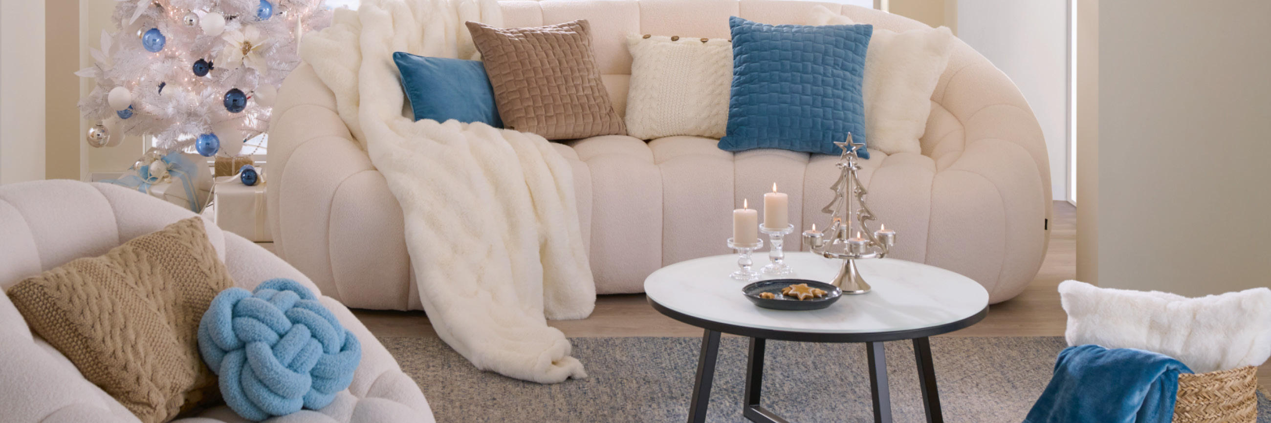 Weiße Couch mit blauen, weißen und braunen Heimtextilien