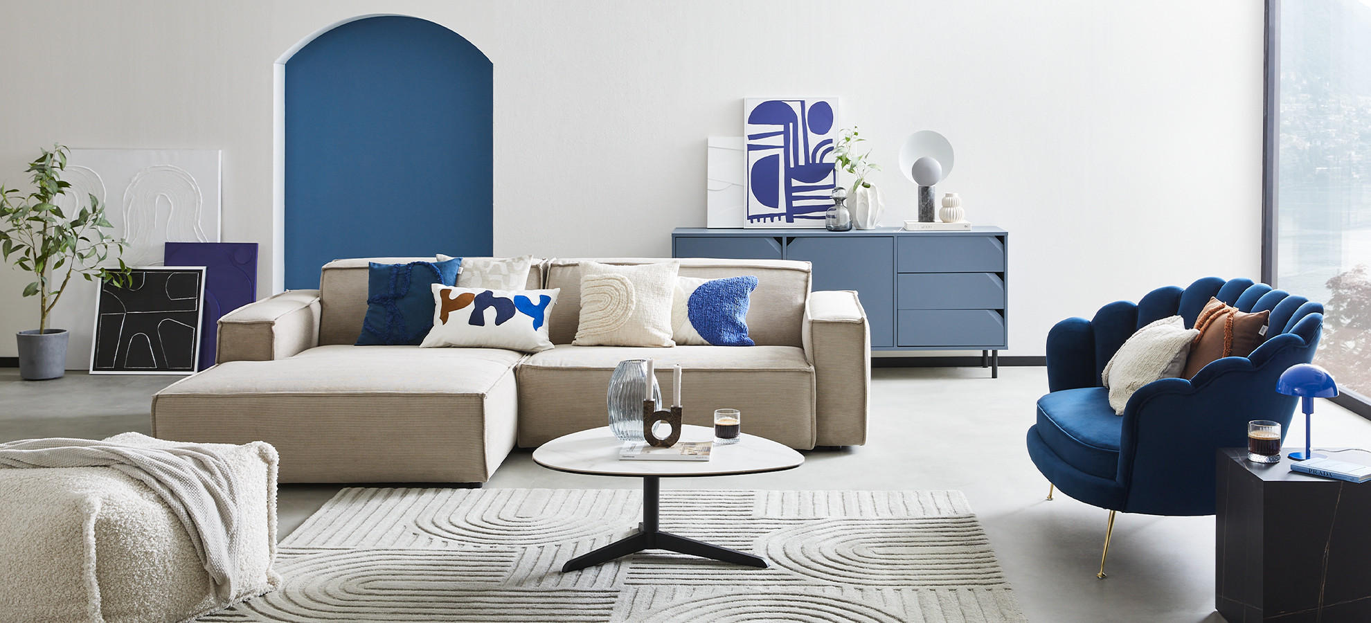 Ecksofa in beige mit Kissen in blau