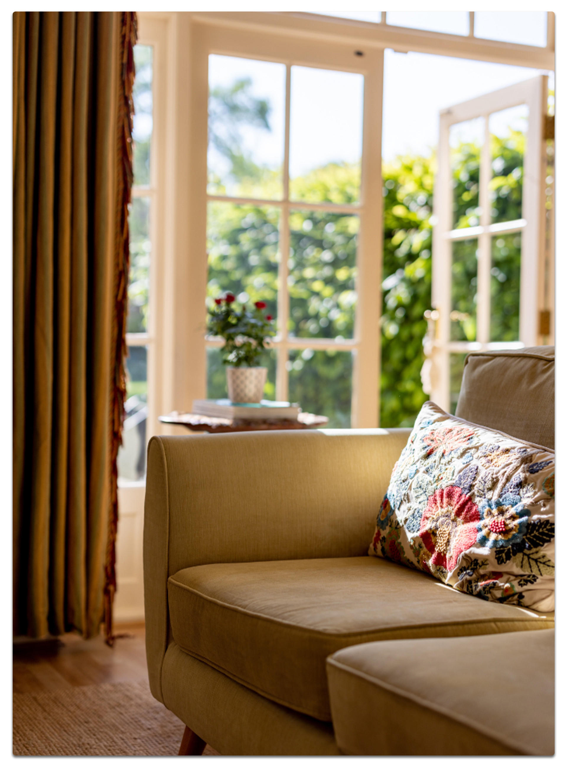 Eine Couch mit einem Kissen und einer Blume darauf, die eine gemütliche und einladende Atmosphäre schafft.