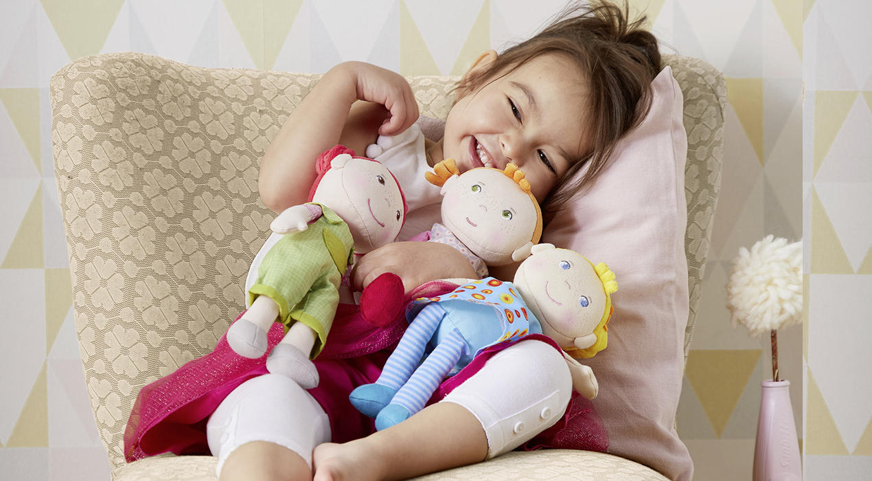 Kind mit Kuschelpuppen von HABA