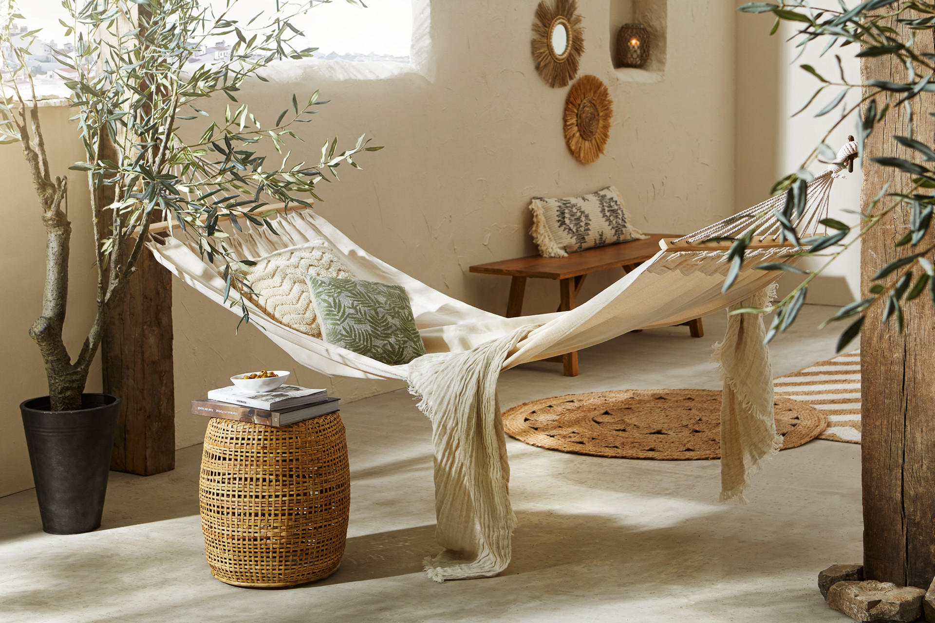 Hojdacia sieť a pletený prútený košík, drevená lavica, okrúhly koberec, dekoračné vankúše