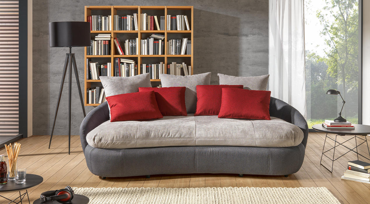 Graues Big Sofa mit roten Kissen