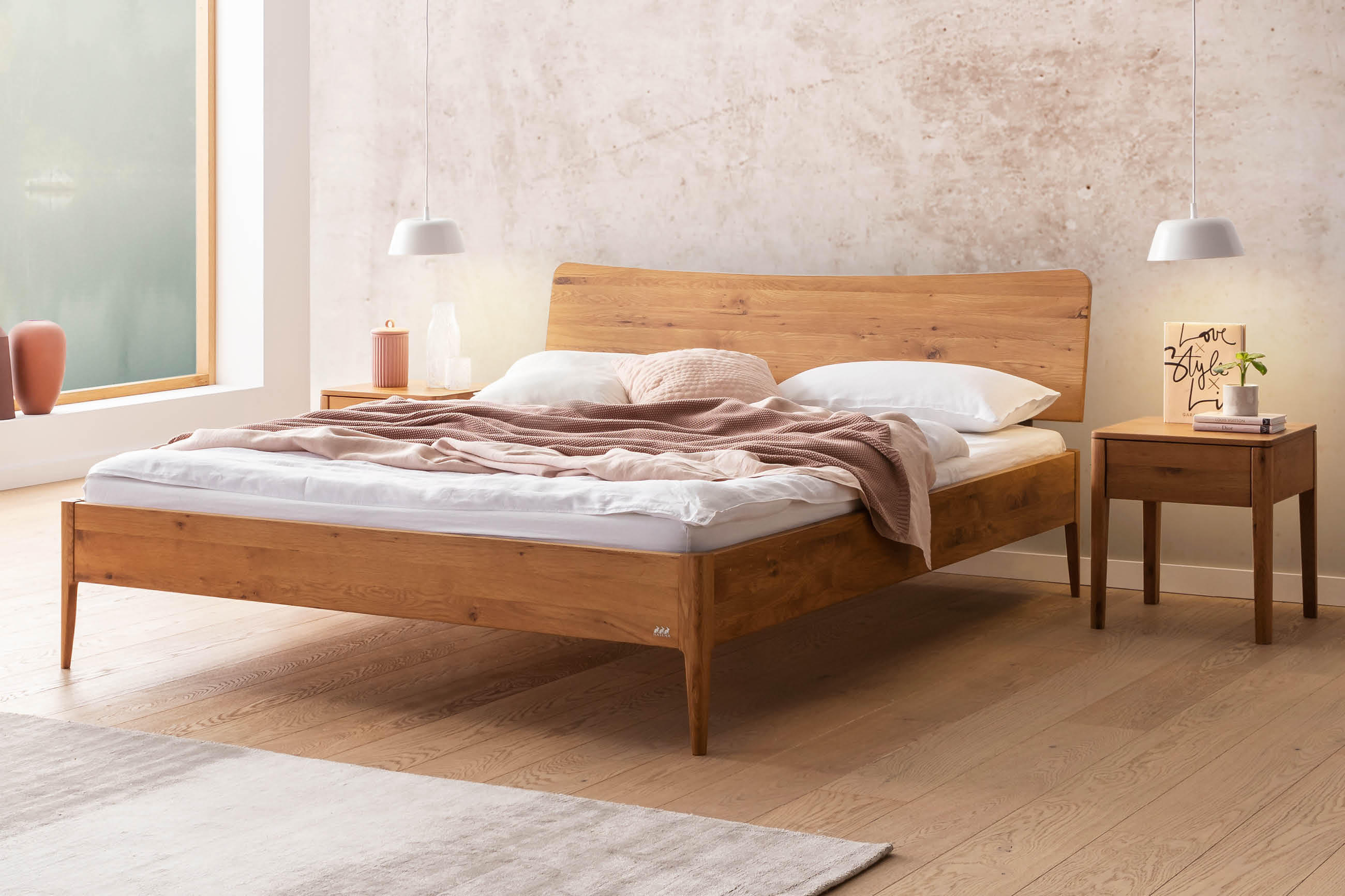 Helles Schlafzimmer mit Hasena Massivholzbett, weicher Bettwäsche und passenden Nachttischen; minimalistische Leuchten und ruhige, natürliche Farbwelt.