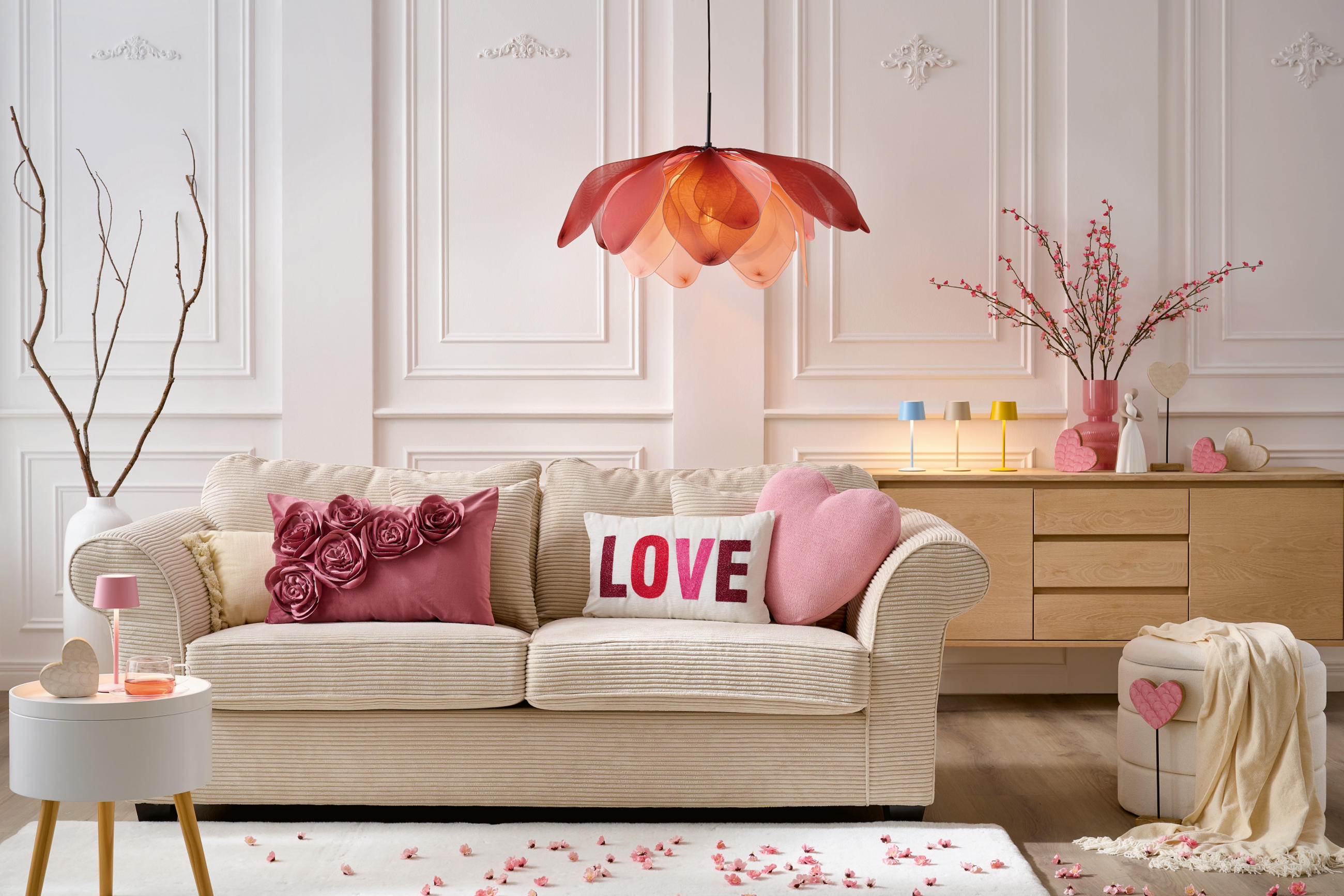 Vardagsrum med vit soffa och rosa detaljer