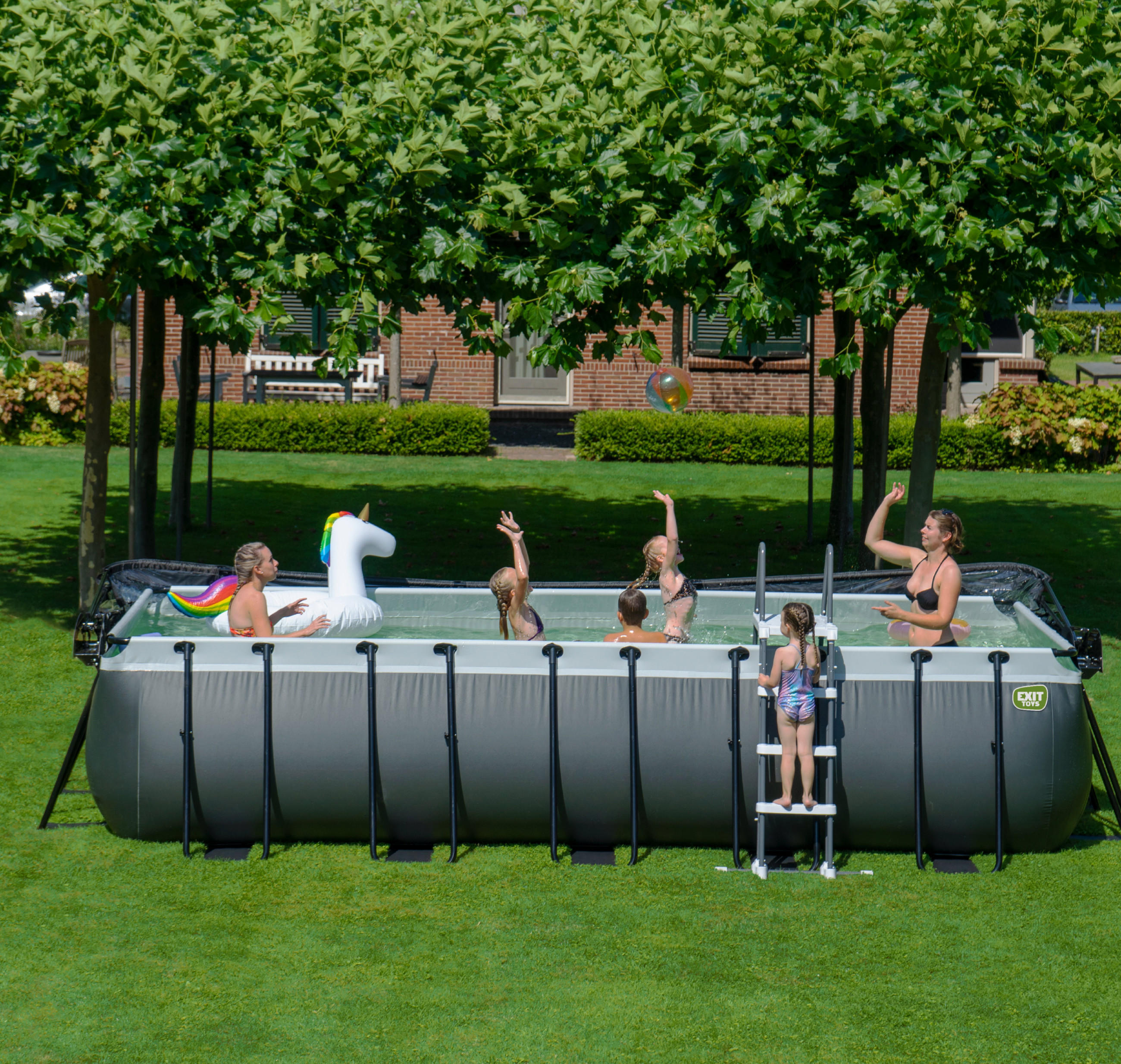 Ein Garten mit einem grossen Pool und einer Familie darin, die spielt