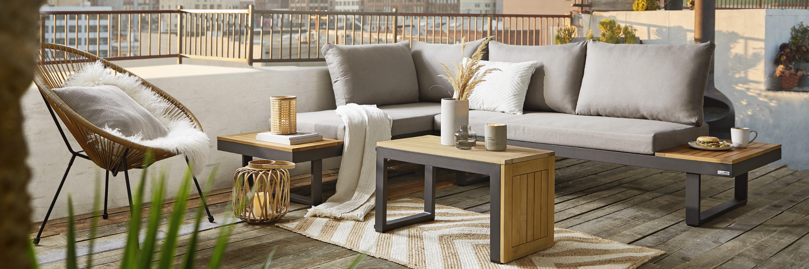 Moderne Gartenlounge auf einem Balkon mit Skyline