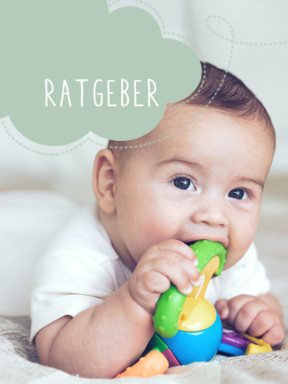 Baby liegt auf dem Boden mit Rassel in der Hand 
