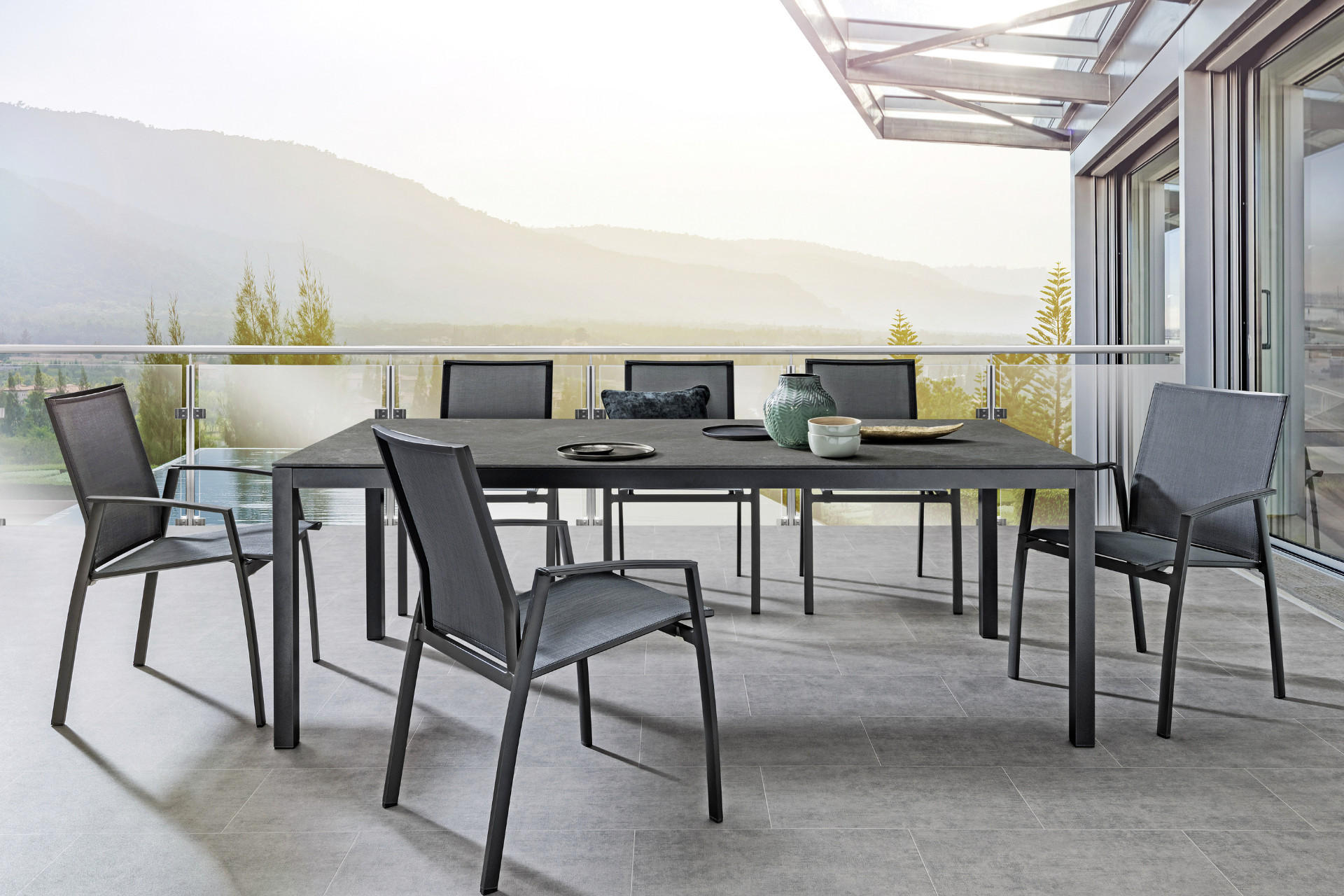 Moderne Terrasse mit Esstisch und Gartenstühlen in grau