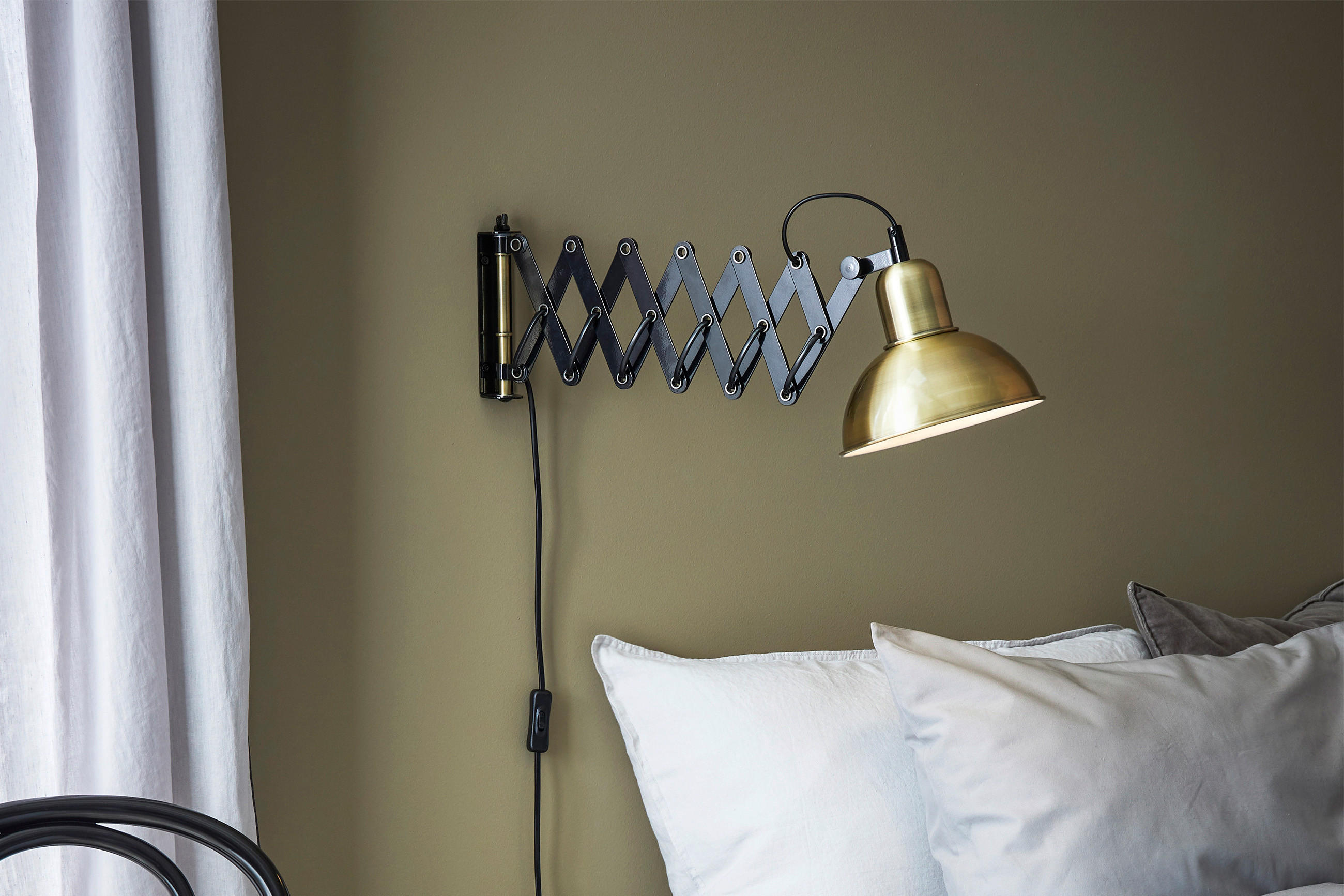 Scherenlampe an der Wand angebracht, um auf der Couch lesen zu können