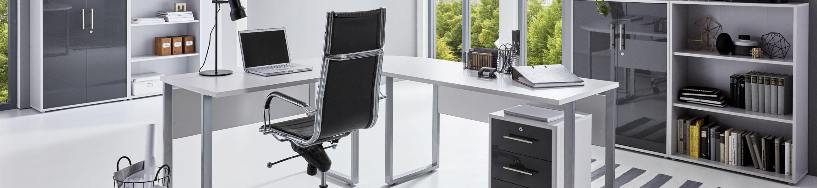 Modernes Büro mit Eckschreibtisch, Bürostuhl, Rollcontainer und Aktenschränken in Weiß, Anthrazit und Hochglanz vor großen Fenstern
